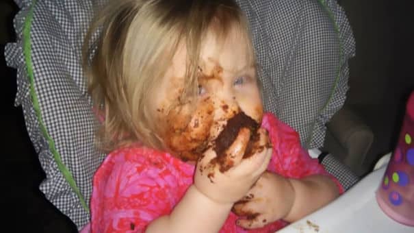 Menina comendo cupcake de chocolate