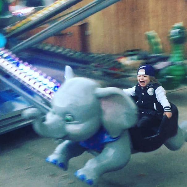 Menino brincando em elefante mecânico