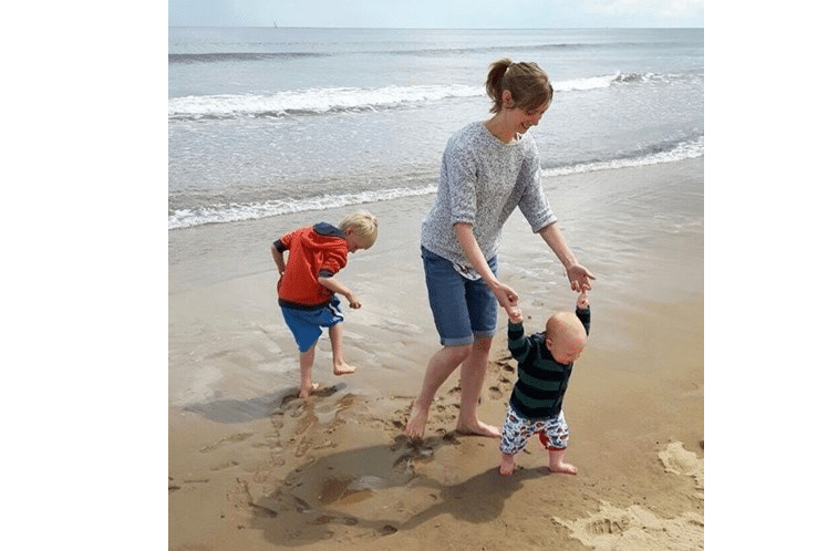 Mulher exausta cuida dos filhos após sessão de quimioterapia