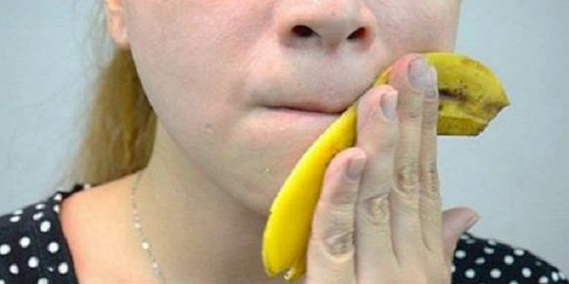 Mulher esfrega casca de banana na pele
