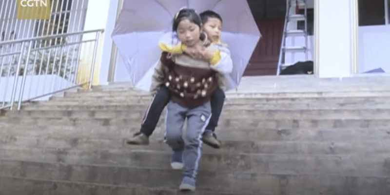 ”Eu serei as suas pernas”, menina de nove anos carrega irmão nas costas todos os dias para levá-lo à escola