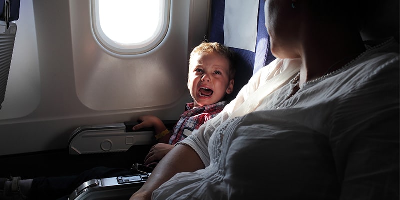 Grávida ajoelha desesperada no aeroporto ao ver seu filho chorar sem parar. Até que estranhas se aproximam