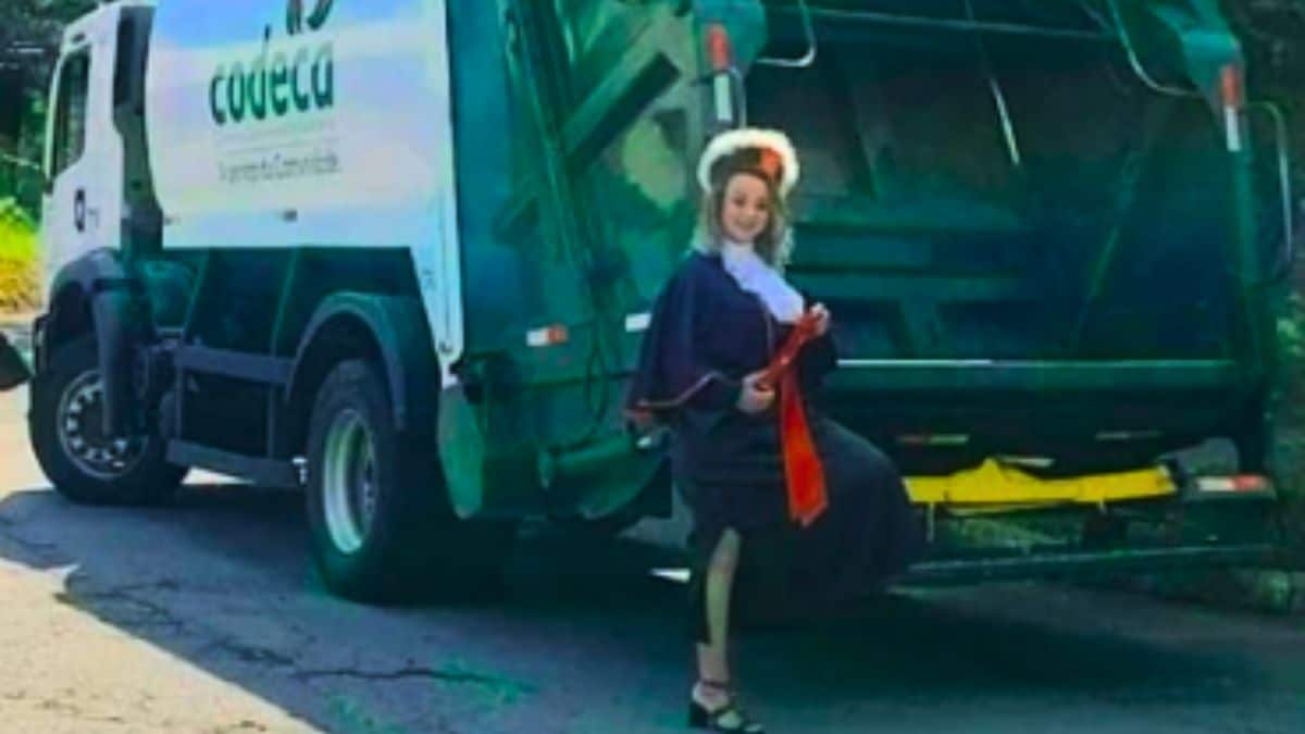 Ex-catadora, se forma e tira foto em frente ao caminhão onde trabalhava.